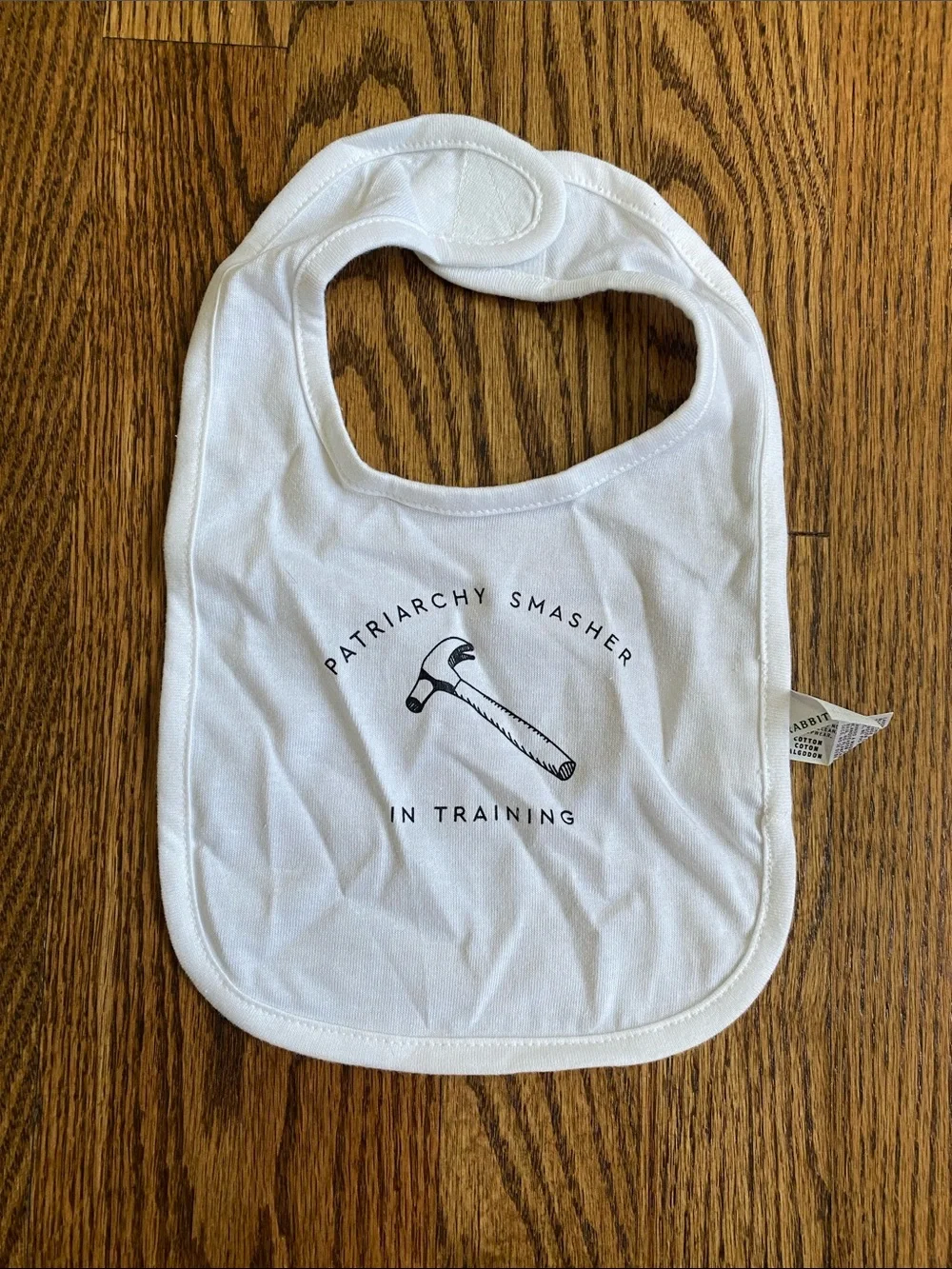 Rabbit Skins White Baby Bib with 'Patriarchy Smasher' Hammer Graphic, like new.